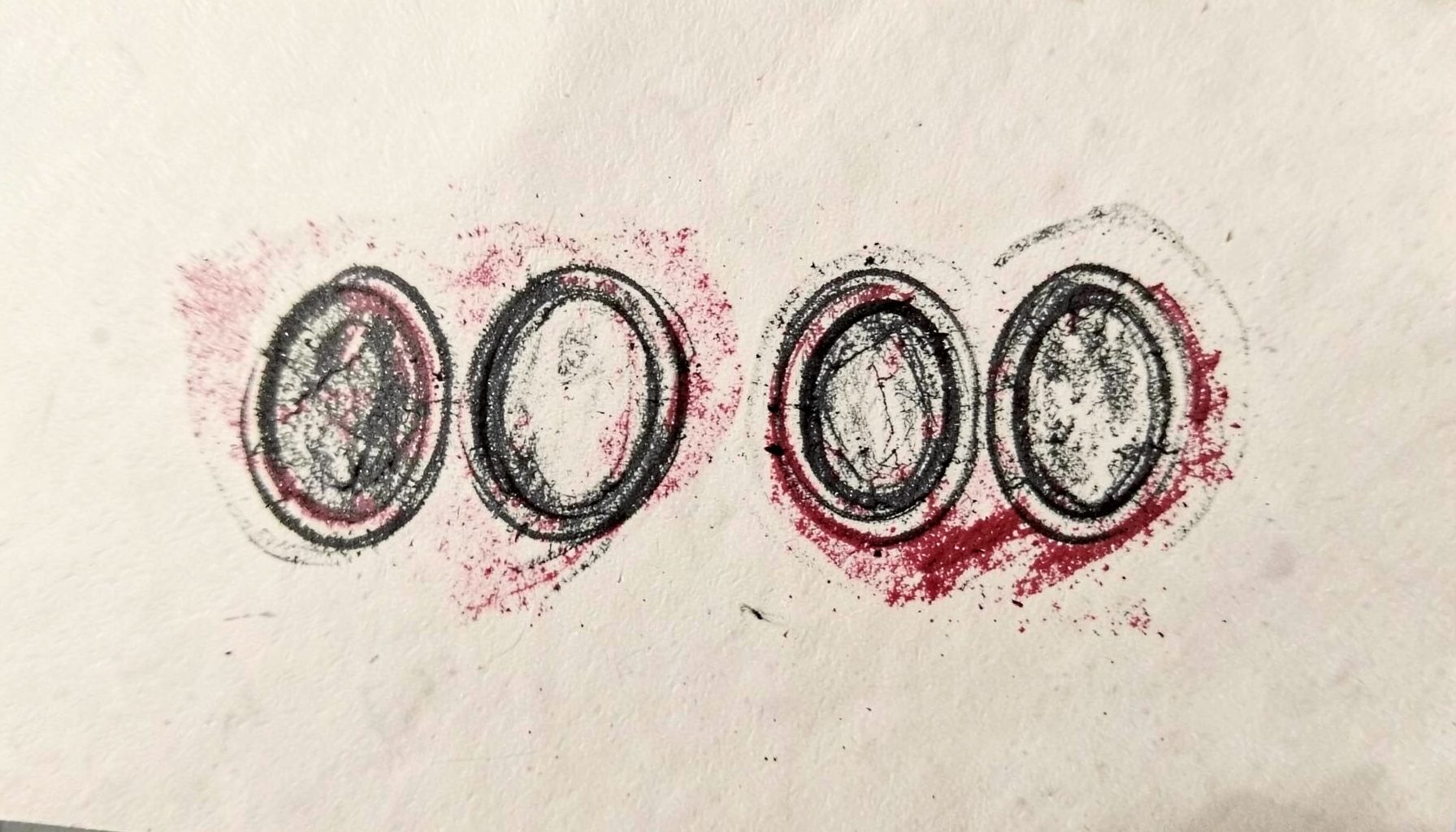 Charcoal sketch of four small oval refill pods arranged in a row on cream parchment with subtle red shading